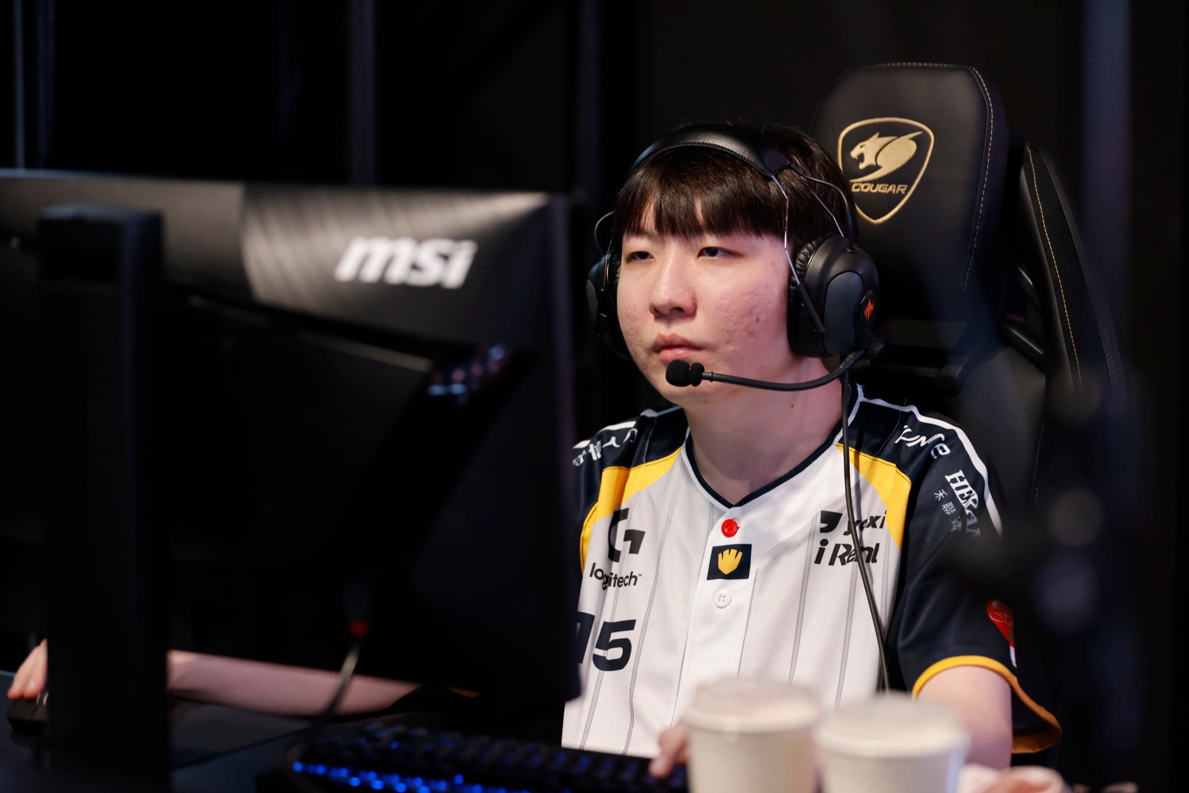 LCP 賽事選手在 MSI 電競螢幕前比賽，耳機麥克風就位