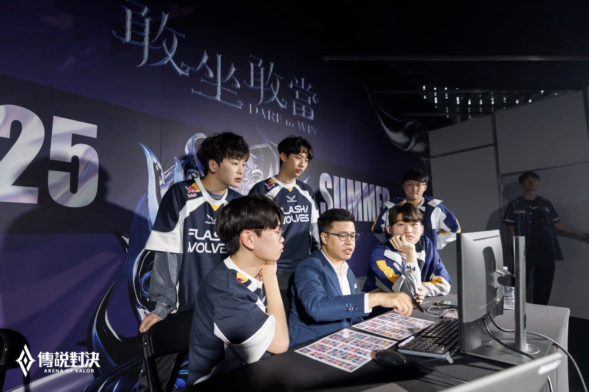 Flash Wolves 隊員與教練在對戰室圍著電腦討論賽中戰術