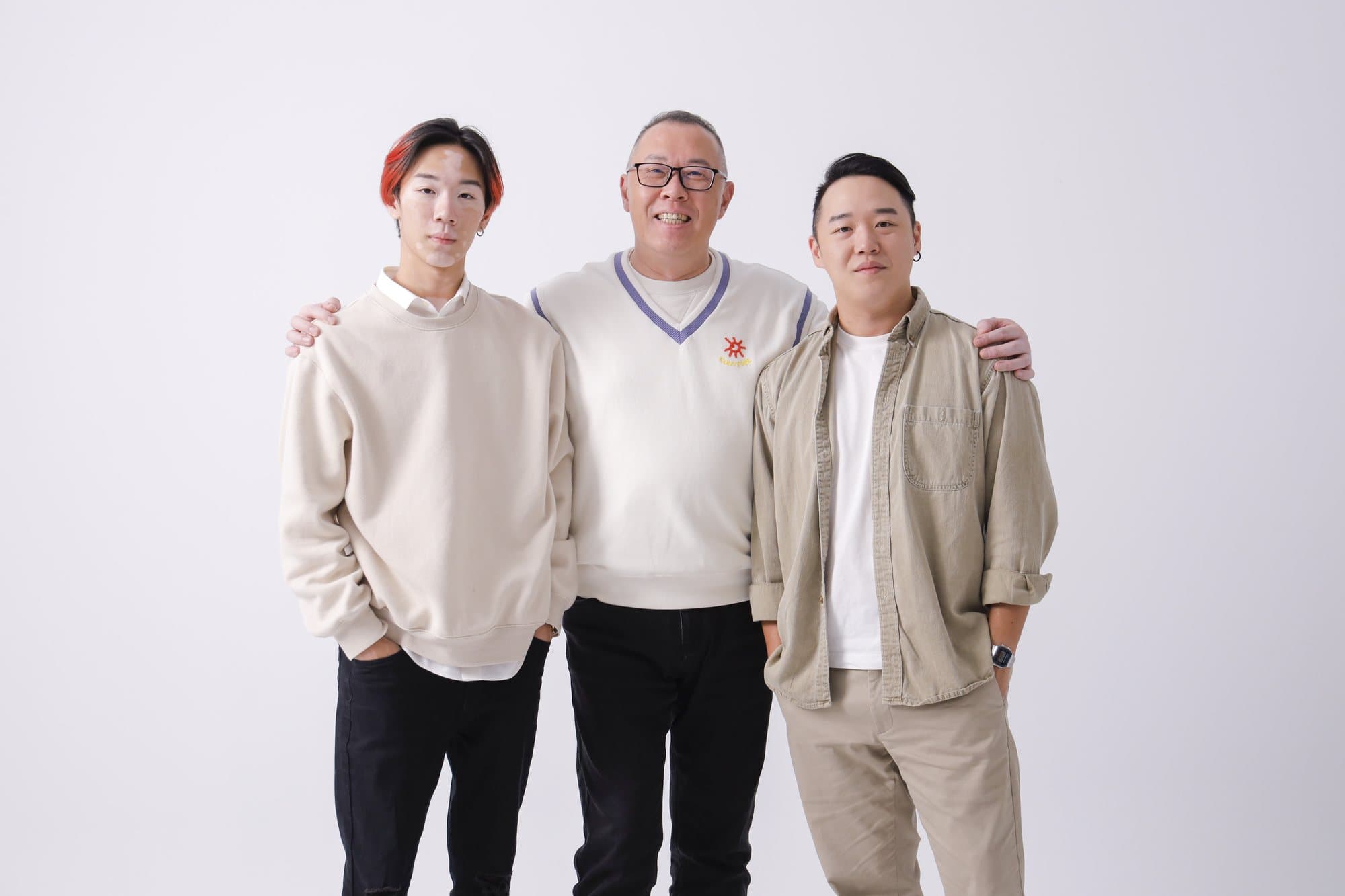 三位家人肩搭肩並肩站立的白棚合影
