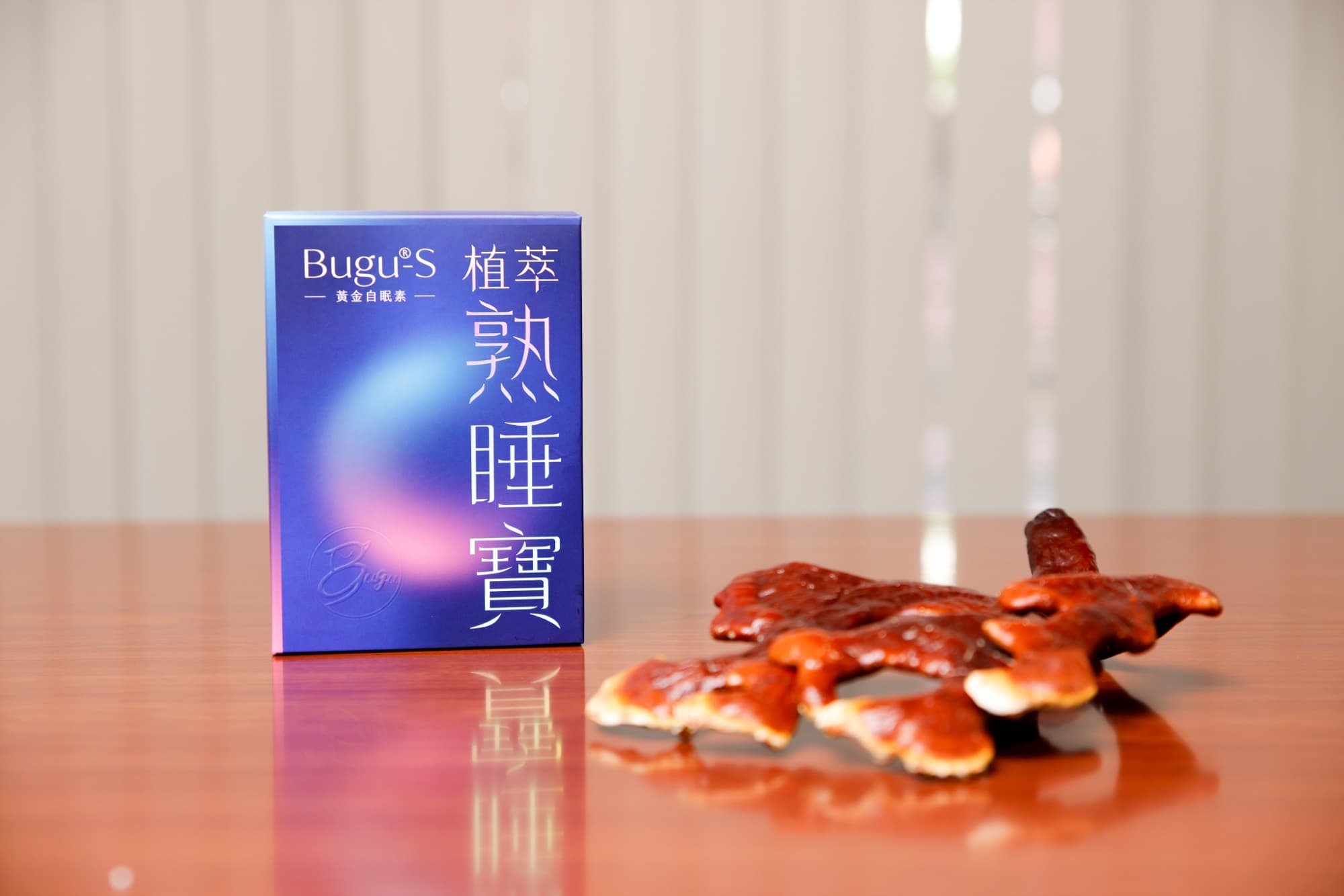 產品盒與鹿角靈芝原料並置於桌面的靜物收尾