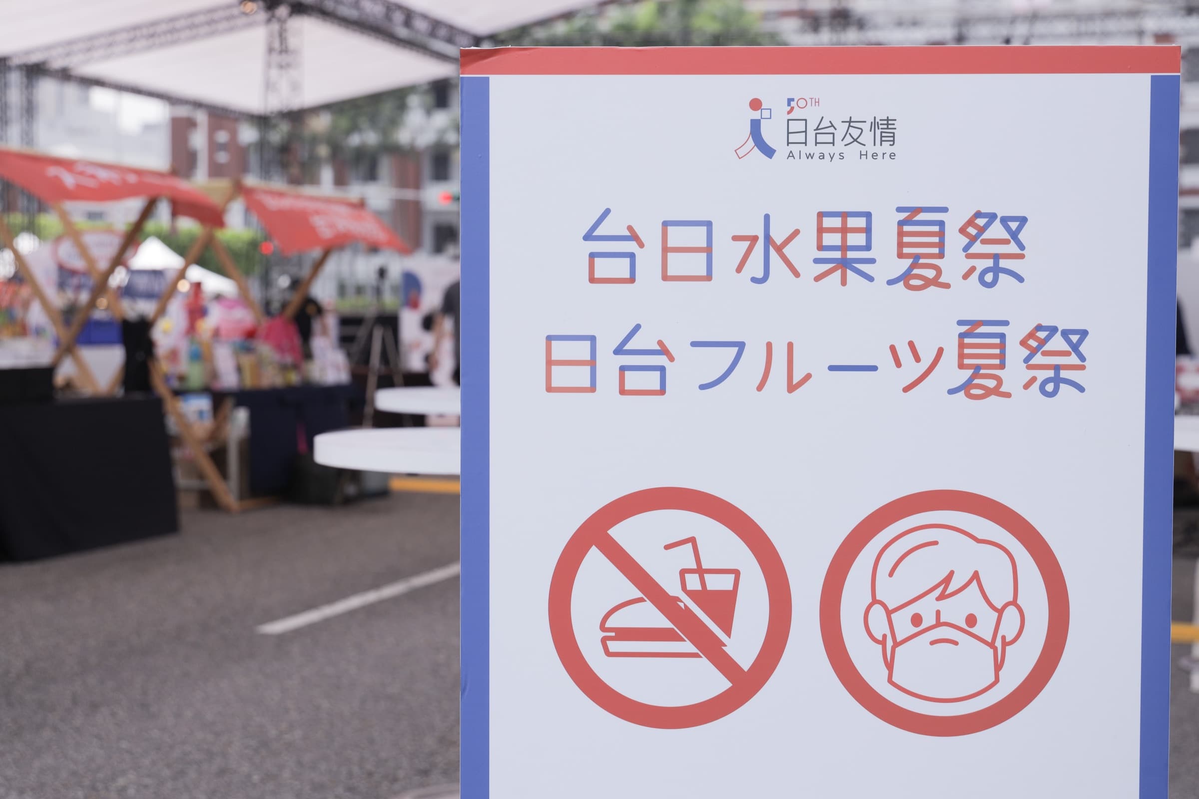 『台日水果夏祭/日台フルーツ夏祭』指示立牌,下方印有禁止飲食與請戴口罩兩個圖示