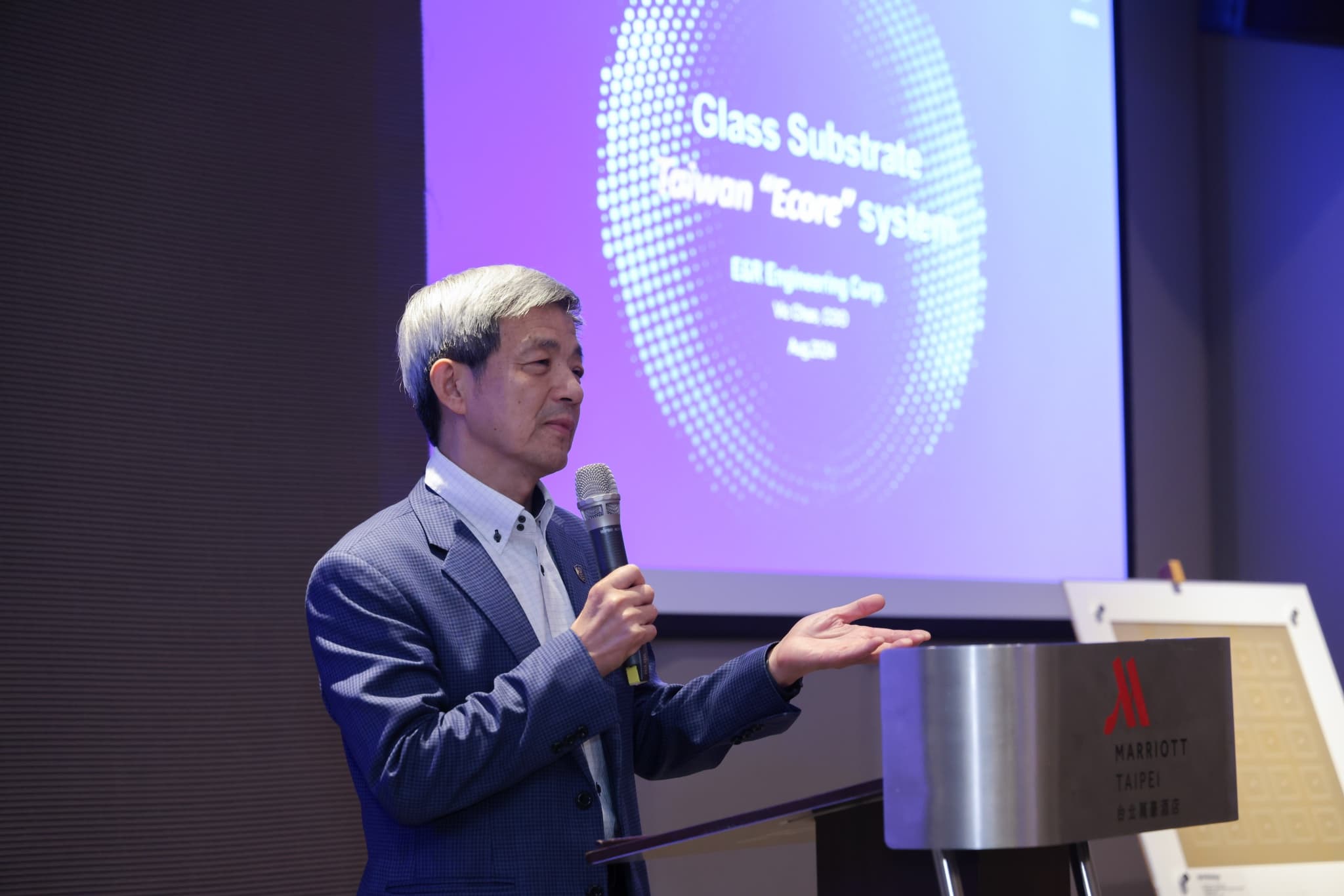 主辦方代表在台北萬豪講台開場致詞,背後投影片顯示 Glass Substrate Taiwan Ecore system