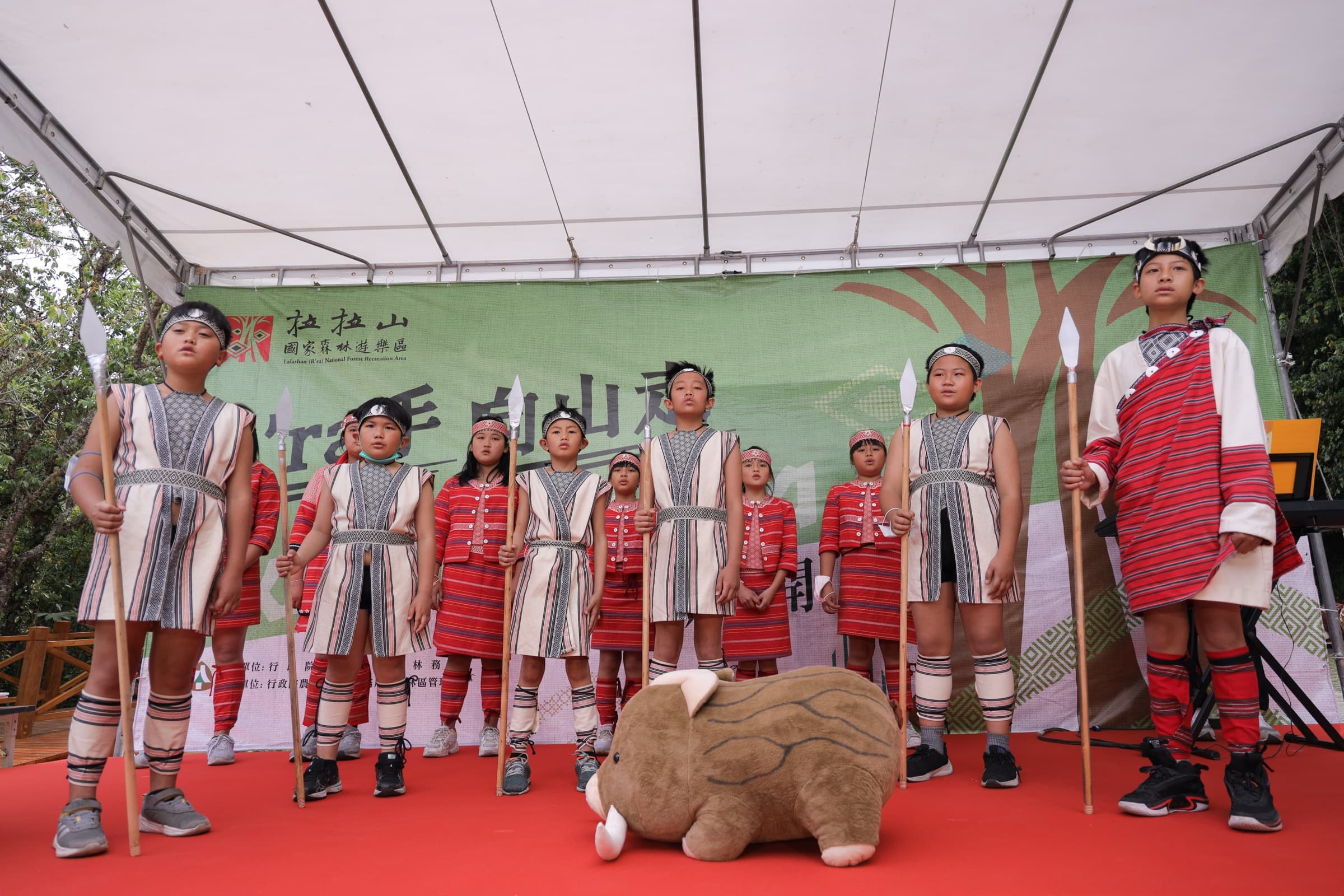 原民少年傳統服飾於舞台上列隊表演