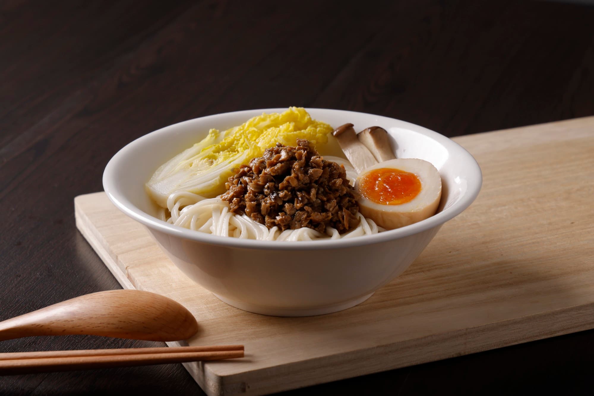 木砧板上麵碗放肉燥、白菜與糖心蛋,暗色背景
