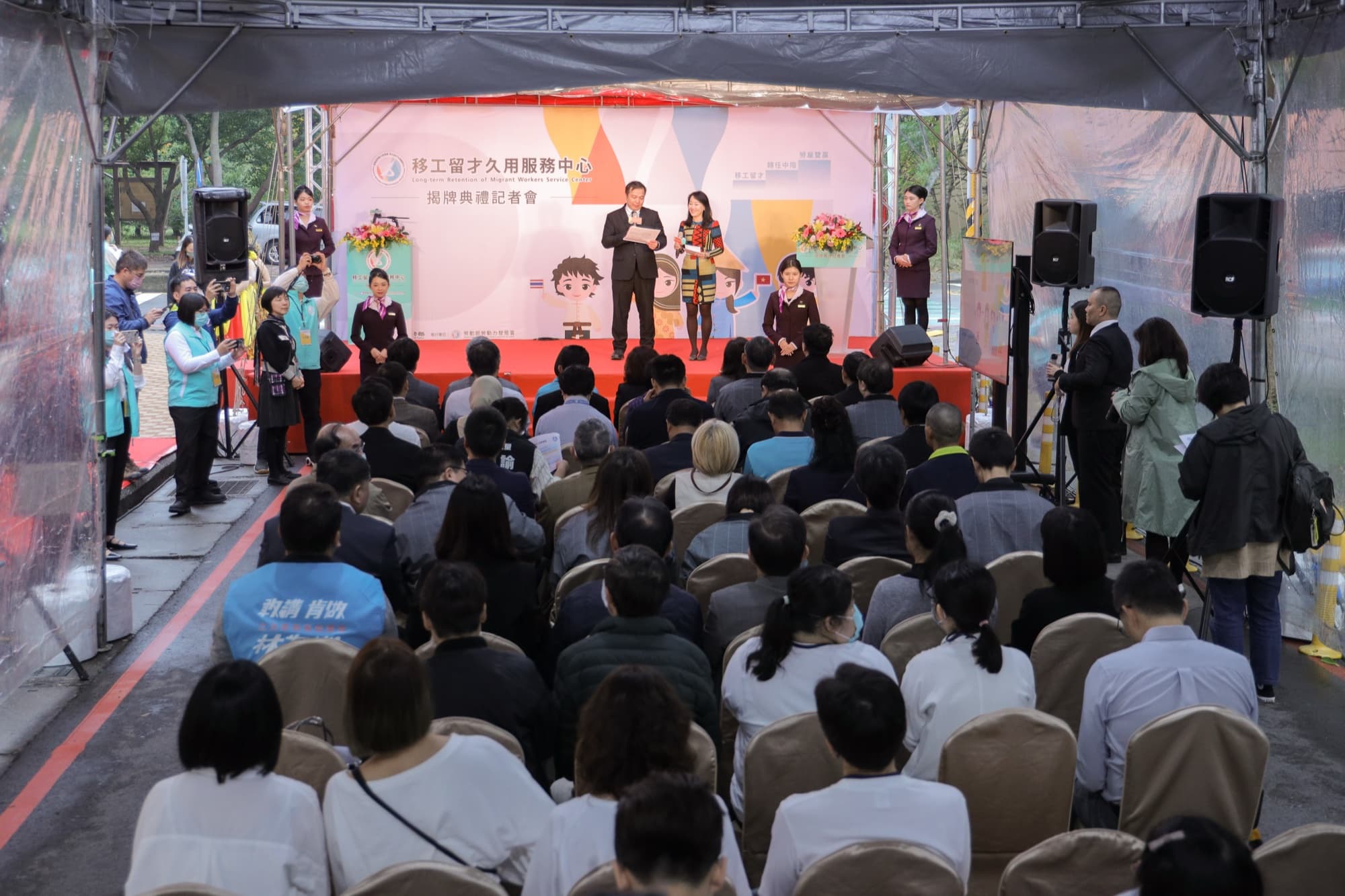 官員與代表在揭牌標誌前合影,背景服務中心可見