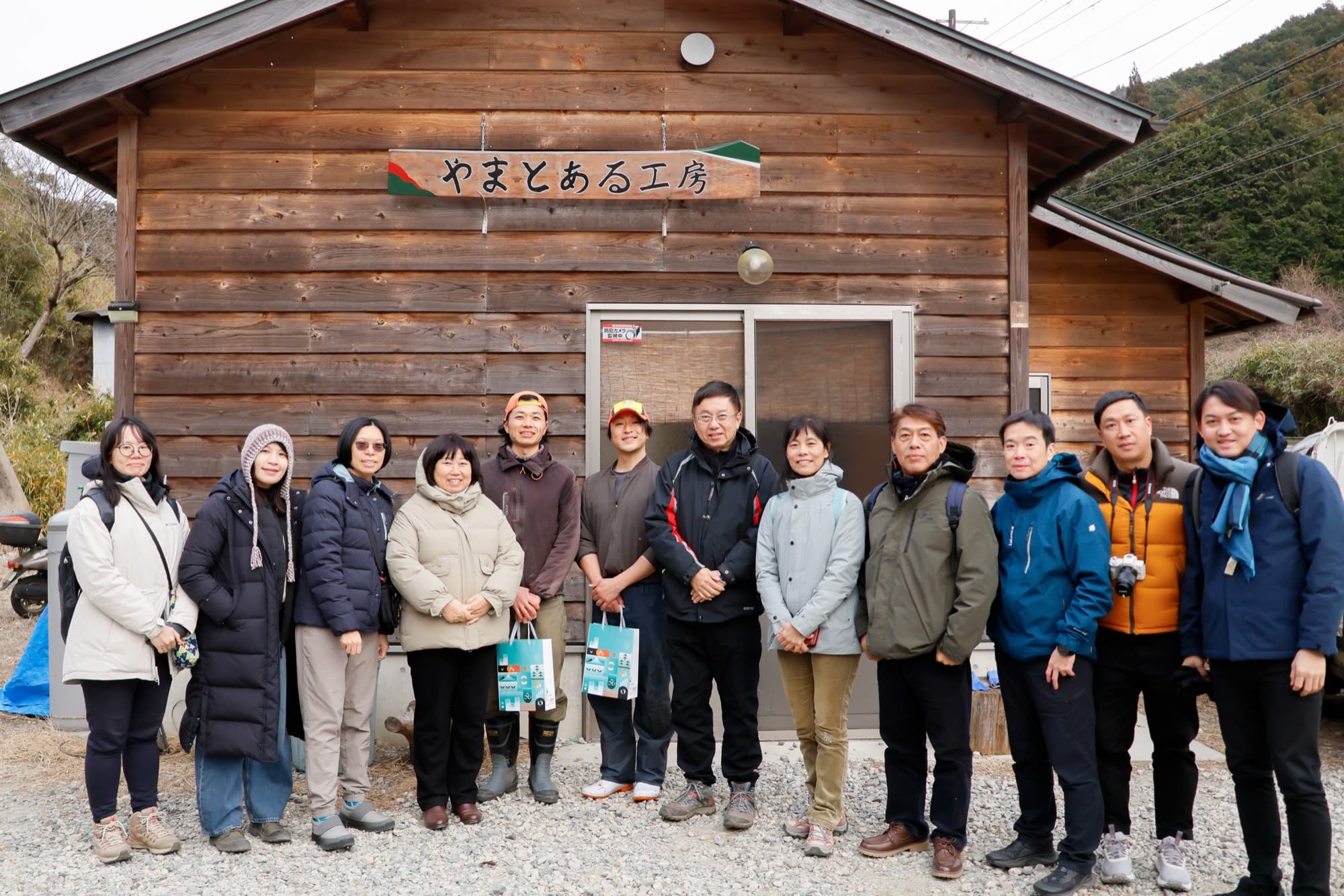 參訪團在山中木造工房招牌前排排合照