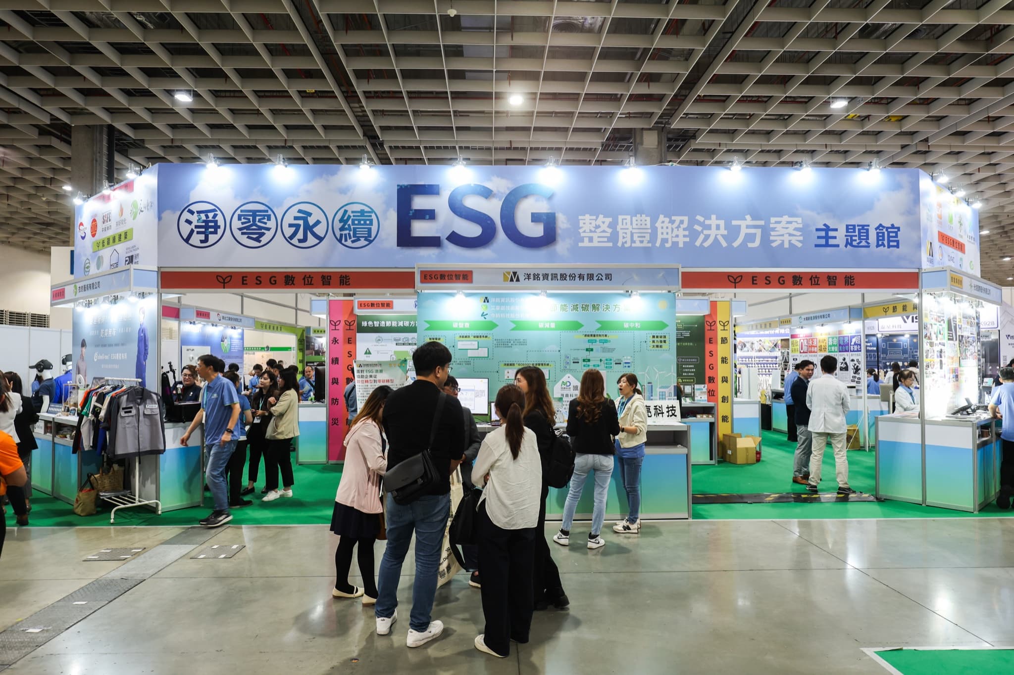主題館正面全景,ESG數位智能分區招牌下多組參觀人潮在各攤位前駐足