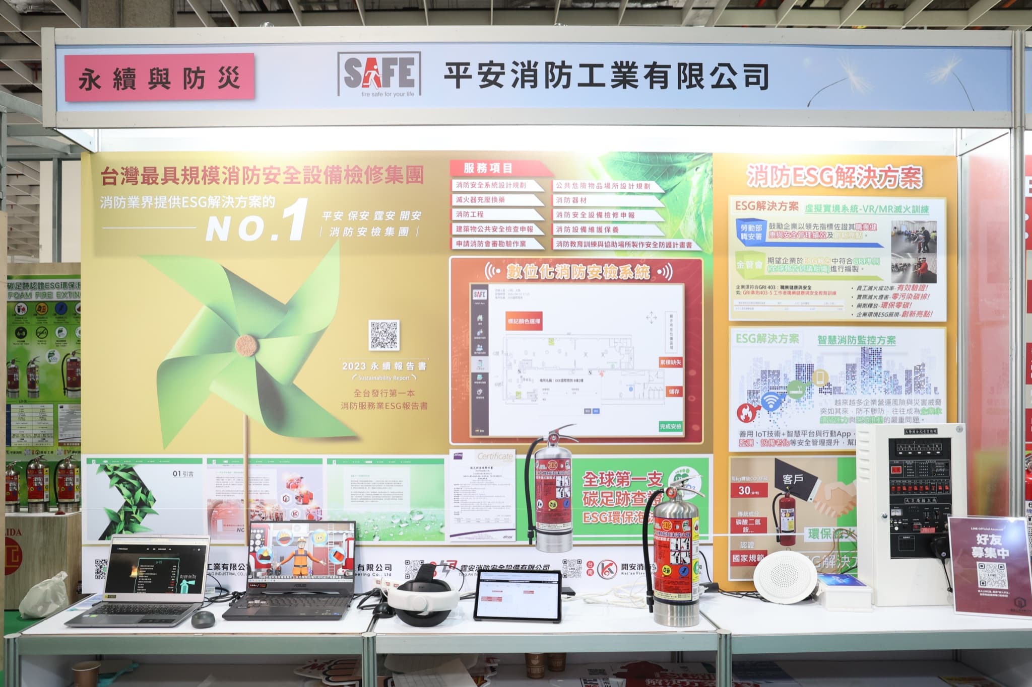 平安消防工業有限公司攤位正面,SAFE楣板下背板列出服務項目、數位化消防安檢系統圖與多款環保滅火器展台