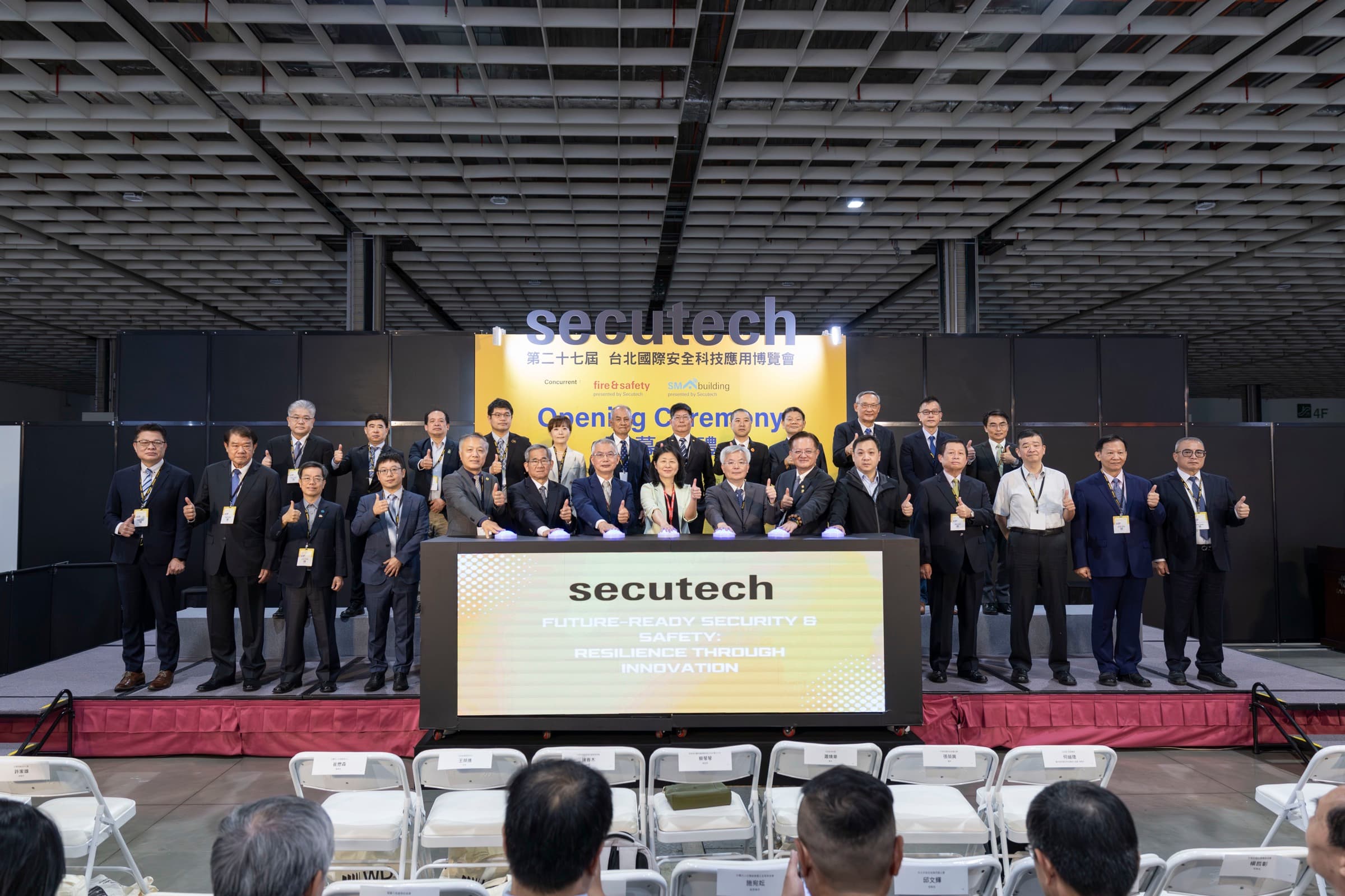 Secutech 開幕舞台上多位貴賓完成正式合影,每個人臉、活動名稱與主視覺清楚可見
