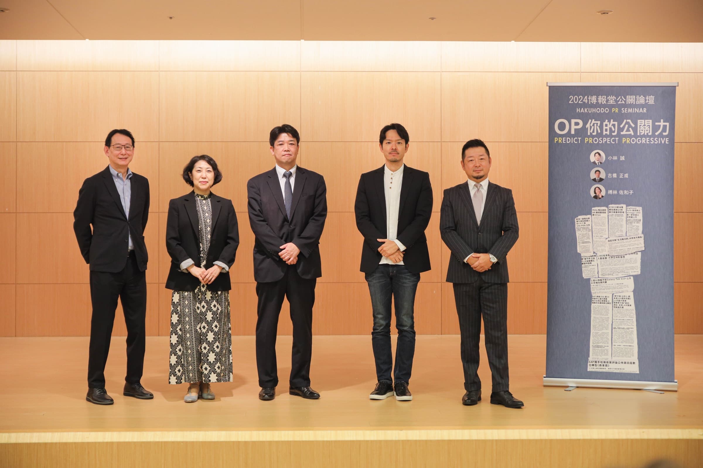 五位論壇講者於印著『2024 博報堂公關論壇 OP 你的公關力』與講者名單的直式主視覺立牌前並肩合影